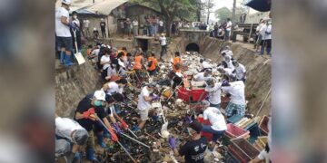 Volunteers remove garbage from a drain near Theinbyu Market in Yangon on Feb. 16. / The Irrawaddy