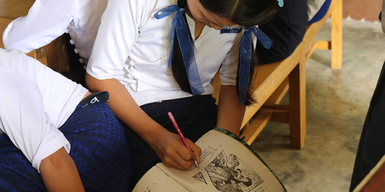 A schoolgirl translates Burmese-language text into Mon at Mon National High School in Ye Township. / ENAC / Supplied