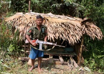 A Burma Army soldier stands guard on Karen State's Mae Tha Waw Road where fighting between a Democratic Karen Benevolent Army splinter group and the Burma Army and allied Border Guard Force militia has continued this week.