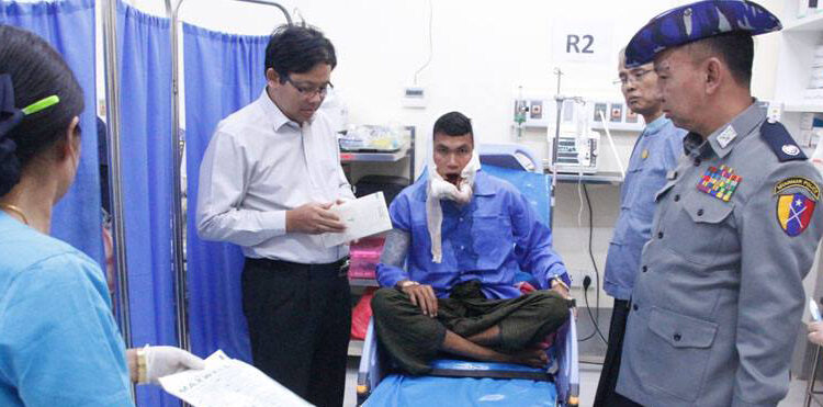 Police Brig-Gen Tin Ko Ko (far right) pays a visit to police private Myo Kyaw Lwin (center), who was wounded during the ambush on Wednesday, at a government hospital in Yangon on January 17, 2019. / Ye Zarni / Facebook