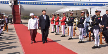 Chinese President Xi Jinping (right) is welcomed by Myanmar Vice President Myint Swe (left) at the airport in Naypyitaw, the capital of Myanmar, on Friday. / Ministry of Information