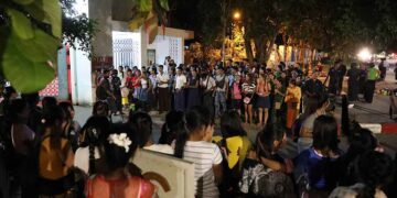 About 200 workers from five garment factories in Yangon gather at the entrance gate of the Yangon regional government office on Tuesday night, asking to meet with the chief minister and for his intervention in a labor rights dispute.  / Myo Min Soe