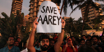 A man displays a placard during a protest demanding that the Mumbai Metro Rail Corp. Ltd (MMRCL) not cut trees to build a train shed for an upcoming subway line, in Mumbai, India on Oct. 6, 2019. / REUTERS