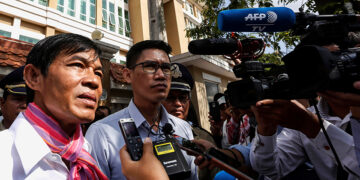 Uon Chhin (left) and Yeang Sothearin, Cambodian journalists from US-funded broadcaster RFA who have been charged with espionage, speak to the media in front of the Municipal Court of Phnom Penh on Oct. 3, 2019. / REUTERS