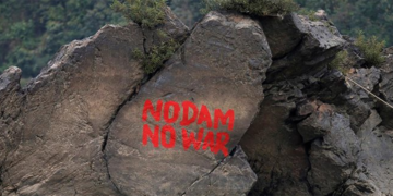A slogan opposing the China-backed Myitsone Dam Project is scrawled on a boulder above the Irrawaddy River. / Reuters