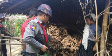 A member of the border police searches a home in Tha Win Chaung village on Friday. / The Irrawaddy