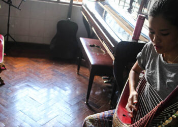 A girl practices a traditional harp at Gitameit. / Chan Son / The Irrawaddy