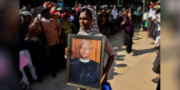 A mourner with U Ko Ni’s portrait at his funeral on January 30, 2017, in Yangon. / The Irrawaddy