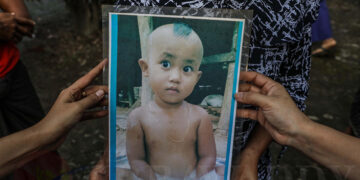 Relatives show a picture of Aung Zin Phyo, who was killed when an artillery shell struck their home on Aug. 24, 2019 in Pan Myaung Village, Minbya Township, Rakhine State. / Zaw Zaw / The Irrawaddy