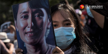 An anti-coup protester holds Daw Aung San Suu Kyi’s portrait in Yangon on Feb. 8. / The Irrawaddy
