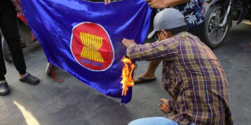 Myanmar people set an ASEAN flag alight in June. / Time for Revolution