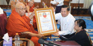 Military chief Senior General Min Aung Hlaing and his wife Daw Kyu Kyu Hla are seen with Sitagu Sayadaw after making a donation to the Sitagu International Buddhist Academy in 2019. / MNA