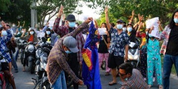 Anti-regime protesters in Mandalay prepare to burn an ASEAN flag in June. / Time for Revolution