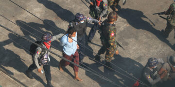 Regime security forces arrest a civilian during a raid in Yangon in March. / The Irrawaddy
