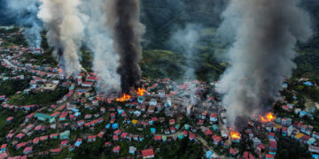 This aerial photo taken on Oct. 29 shows smoke and fire in Thantlang, in Chin State, where more than 160 buildings have been destroyed due to shelling by junta troops. / AFP