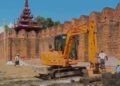An excavator digs near Mandalay Palace Wall as part of the junta’s recreation park project. / CJ