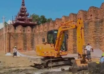 An excavator digs near Mandalay Palace Wall as part of the junta’s recreation park project. / CJ