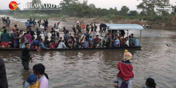 Civilians crossing the Thaung Yin River on Sunday to take shelter in Thailand after junta shelling near Myawaddy, Karen State. / The Irrawaddy