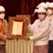 Coup leader Snr-Gen Min Aung Hlaing presents a religious title and insignia to a recipient. / Cncds