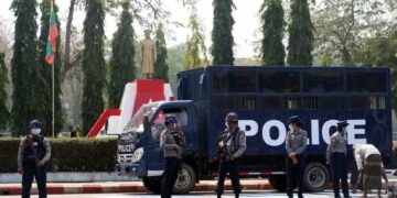 Police on guard by the bronze statue of General Aung San in Pyinmana Township.