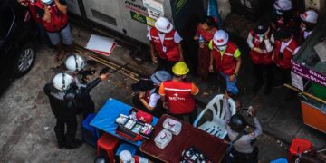 A police officer points his gun at a medical worker during the crackdown on anti-regime protests in Yangon.