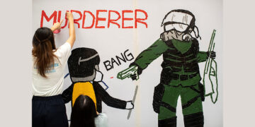 Hong Kong anti-government protesters create a mural on Oct. 2, 2019 depicting a student protester who was shot and wounded by police with live ammunition. / REUTERS