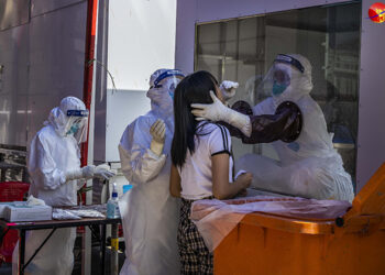Health workers administer a test for COVID-19 at the Tourist Burma Building in Yangon. / Htet Wai / The Irrawaddy