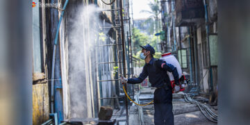 A fire service staffer disinfects an alley in Yangon to curb the spread of the coronavirus. / Htet Wai / The Irrawaddy
