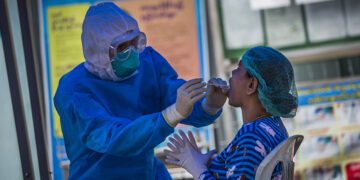 A Yangon resident has a swab sample taken for COVID-19 testing.