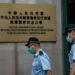 Police officers walk past a plaque outside the Office for Safeguarding National Security of the Central People’s Government in Hong Kong on Wednesday. / GETTY / KYODO