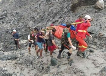 Rescuers carrying the bodies of those buried alive by a landslide at a Hpakant jade mine in Kachin State on Thursday. / Myanmar Fire Services Department