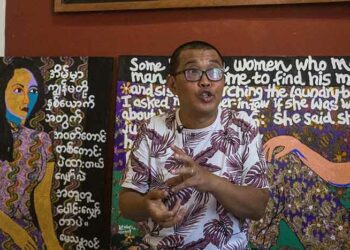 Artist Htein Lin sits at one of the pieces that will be exhibited in his upcoming exhibition, Skirting the Issue, at River Gallery. / Aung Kyaw Htet / The Irrawaddy