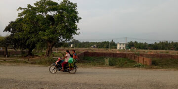Motorists pass residential blocks prepared as part of the new town project on the outskirts of Taungup Township. / Moe Myint / The Irrawaddy