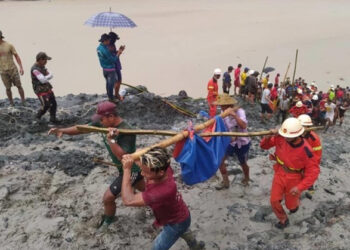 A rescue team carry a dead body after the Hpakant landslide. / Myanmar Fire Service Department.