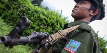 A TNLA soldier stands guard in northern Shan State in June 2014. TNLA is among those banned by Facebook on Tuesday. / The Irrawaddy