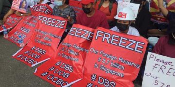 Anti-coup protesters stage a sit-in protest near the Singapore Embassy in Yangon on Wednesday, demanding Singapore's banks freeze Myanmar's foreign reserves. / Aye Thandar