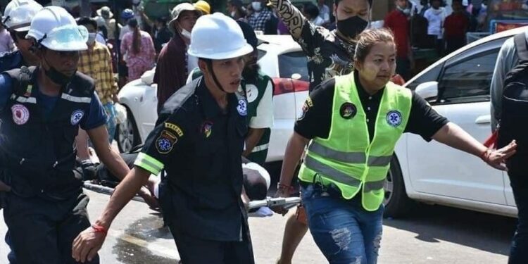 Rescue workers from the Thukha Kari charity carry away a wounded protester during a police crackdown on an anti-regime protest in Yangon.