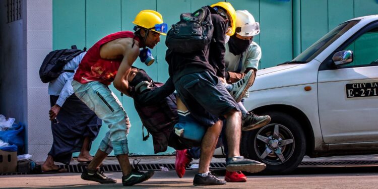 Anti-coup protesters carried a protester who was wounded during a crackdown by security forces in Yangon. / The Irrawaddy