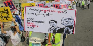 Anti-coup protesters hold placards demanding the release of Professor Sean Turnell in Mandalay. / The Irrawaddy