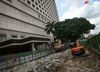 Workers from the Yangon City Development Committee (YCDC) dig up a stretch of Sule Pagoda Road previously occupied by the Sule Shangri-La hotel’s private car park and signage