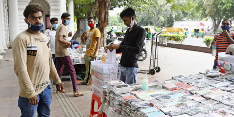 Vendors wearing masks peddle their wares in a commercial district in New Delhi on Sept. 4, 2020. / Kyodo