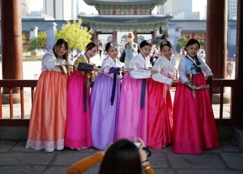 Tourists wearing Korean traditional costumes, known as Hanbok, pose for photographs at the Gyeongbok Palace in central Seoul, South Korea, in October 2016. / Reuters