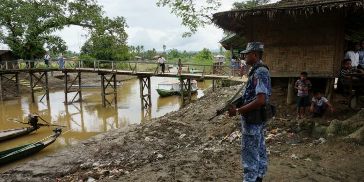 A Myanmar border guard police officer stands guard in Taung Bazar village, Buthidaung Township, northern Rakhine State, on July 13, 2017. / Reuters