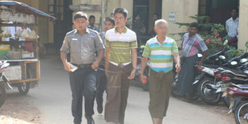 Capt. Aung Ko Min, center, is escorted by police in front of the court building in Moulmein, Mon State on Dec. 10, 2018. / Mon News Agency