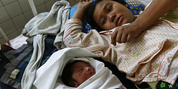 A woman lies near her newborn baby in North Dagon Township hospital in Rangoon in January 2014. / Soe Zeya Tun / Reuters