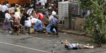 Kenji Nagai of APF tries to take photographs as he lies injured after police and military officials fired upon and then charged at protesters in Yangon on Sept. 27, 2007. Nagai, 50, a Japanese video journalist, was shot by soldiers as they fired to disperse the crowd. Nagai later died. / Reuters