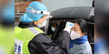 A security officer wearing a protective mask checks the temperature of a passenger following the outbreak of a new coronavirus, at an expressway toll station on the eve of the Chinese Lunar New Year celebrations in Xianning, a city bordering Wuhan in China’s Hubei province on Jan. 24, 2020. / REUTERS