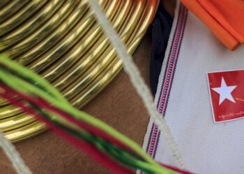 An ethnic Kayan woman wearing a National League for Democracy (NLD) sticker with an image of Myanmar pro-democracy leader Aung San Suu Kyi, waits for Suu Kyi's arrival during the latter's campaign for the then-upcoming general election, in Demoso, Kayah state September 10, 2015. / Reuters