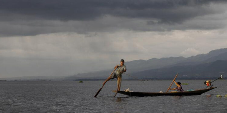 A fisherman paddles his boat with one leg on Inle lake, in Myanmar's Shan State. / Reuters