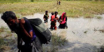 Rohingya people wade through water as they try to reach the Bangladesh side of the border from No Man’s Land after hearing a gunshot from the Myanmar side, in Cox’s Bazar, Bangladesh on Aug. 28, 2017. / Reuters